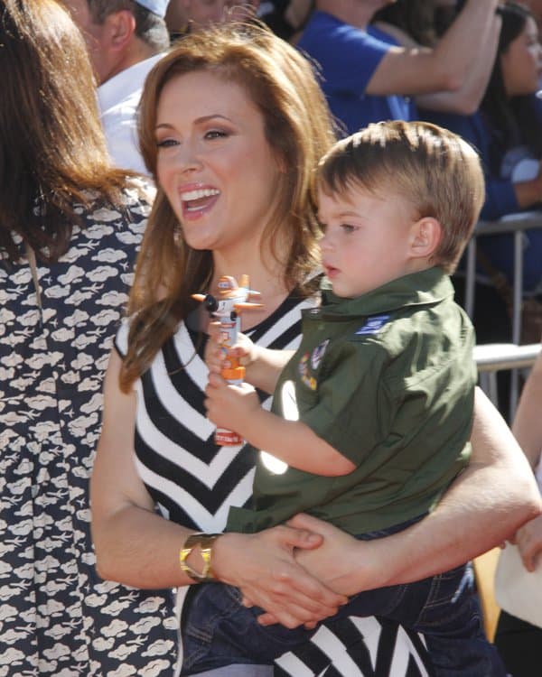 Alyssa Milano, in an elegant RVN flare dress, alongside her son Milo at the Hollywood premiere of Disney's 'Planes'