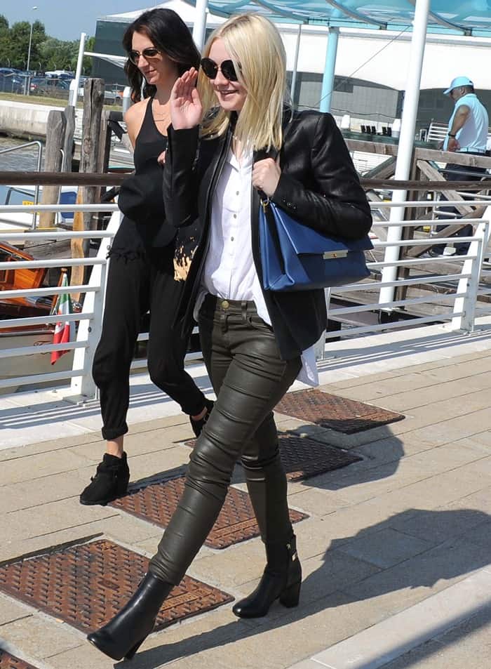 Dakota Fanning wore a white polo shirt, green leather pants from Current/Elliott, black booties, and a black leather jacket