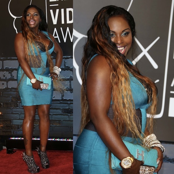 Foxy Brown made a statement at the MTV VMAs in a teal bodycon dress with black lace accents, accessorized with sparkling jewelry, a crystal-studded clutch, and bold spiked Giuseppe Zanotti “Gaga” heel-less boots