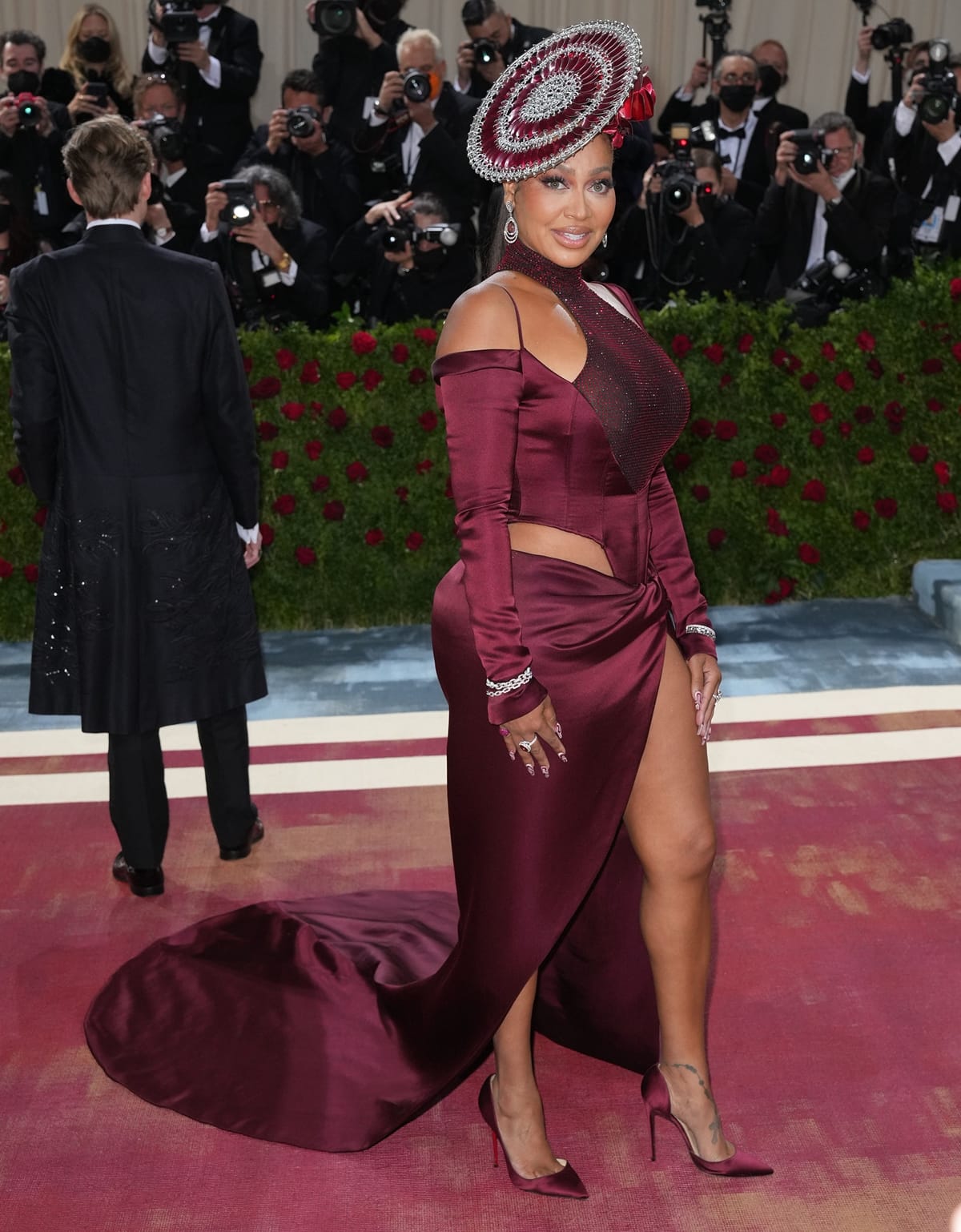 La La Anthony stuns in a burgundy LaQuan Smith gown paired with matching satin Christian Louboutin pumps at the 2022 Met Gala, perfectly embodying the night’s Gilded Glamour theme