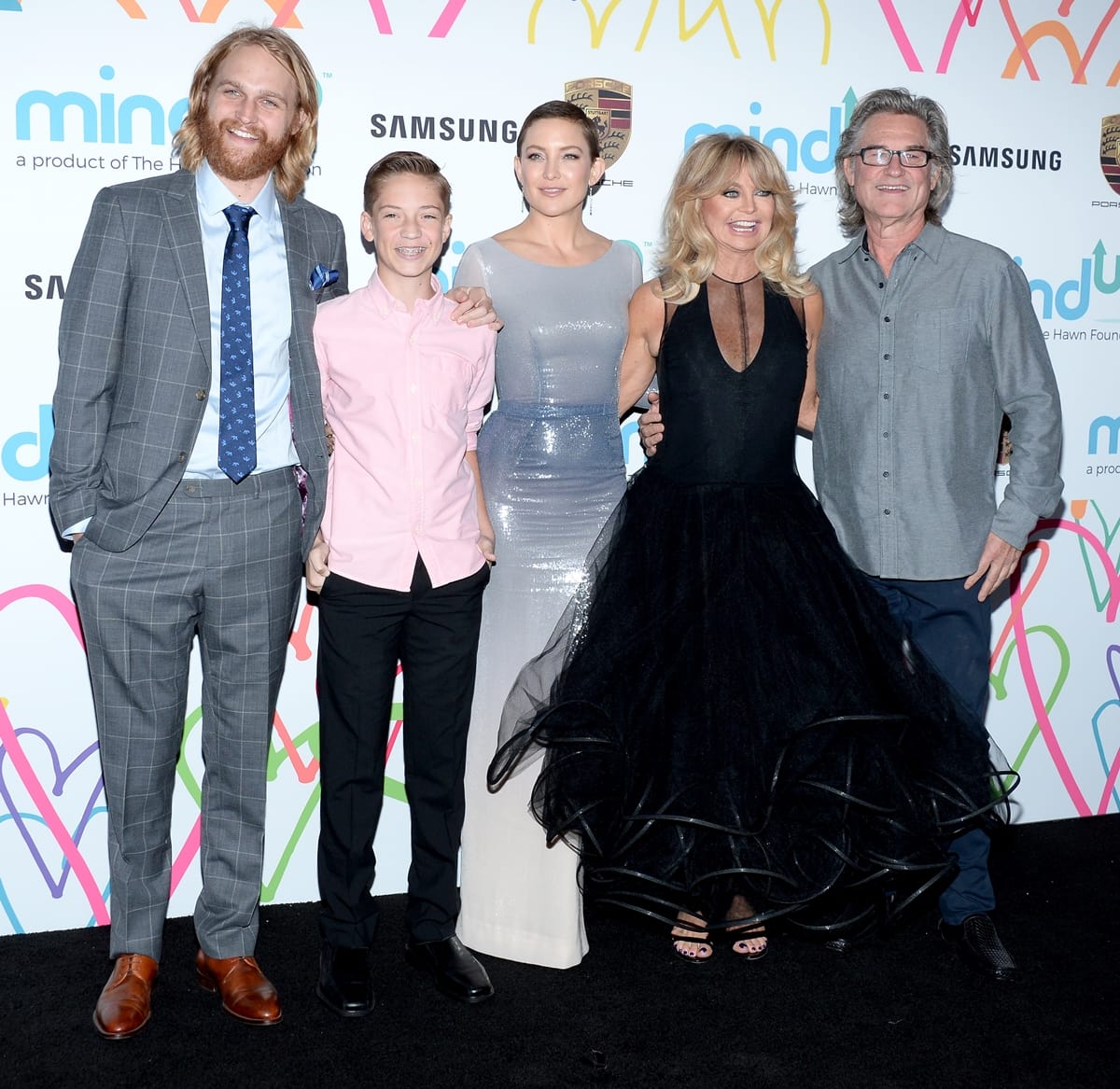 Kate Hudson joins Wyatt Russell, Ryder Robinson, Goldie Hawn, and Kurt Russell at Goldie’s Love In For Kids on November 3, 2017, in Beverly Hills, wearing a Pamella Roland Spring 2018 ombré gown finished with Christian Louboutin “Louloudancing” sandals