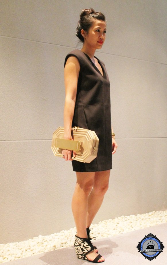 Elaine Liao stuns in a minimalist black dress, pairing bold patterned heels with a sculptural gold clutch for a look that’s equal parts edgy and elegant