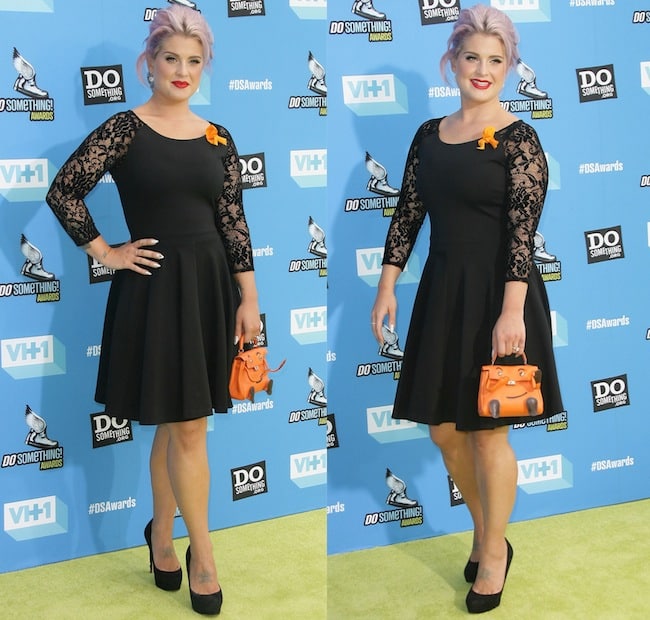 Kelly Osbourne paired a black A-line dress with sheer lace sleeves and classic black platform pumps, adding her signature playful touch with a vintage orange Hermès handbag at the 2013 Do Something Awards