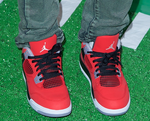 Adrienne Bailon’s red-and-black Air Jordan sneakers made a bold statement with mesh paneling, black laces, and signature Jumpman branding on the tongue