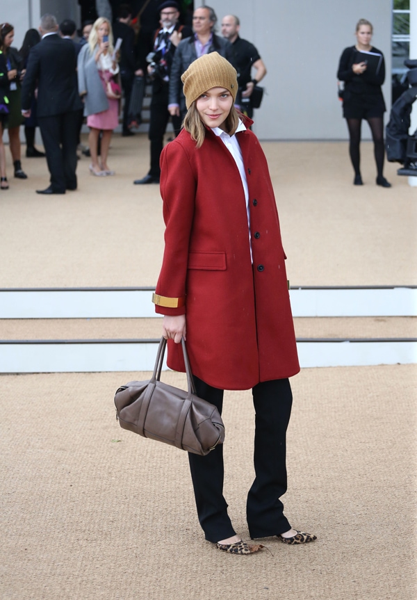 Arizona Muse turns heads in a bold red coat styled with tailored black trousers and playful leopard-print flats