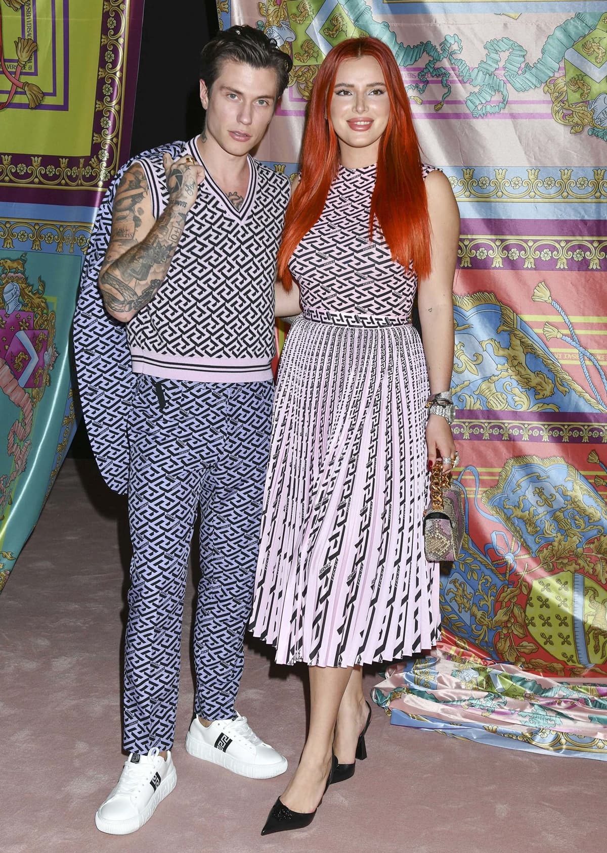 Benjamin Mascolo and Bella Thorne turn heads in coordinated geometric-print ensembles, with Bella elevating her look in sleek black pointed-toe pumps and a pleated pink midi dress
