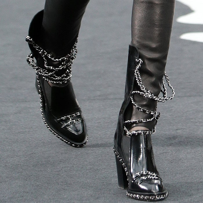 Chanel’s Fall 2013 runway showcased the chain-strapped loafer boots in their intended biker-chic styling, complete with glossy leather and bold silver chain details