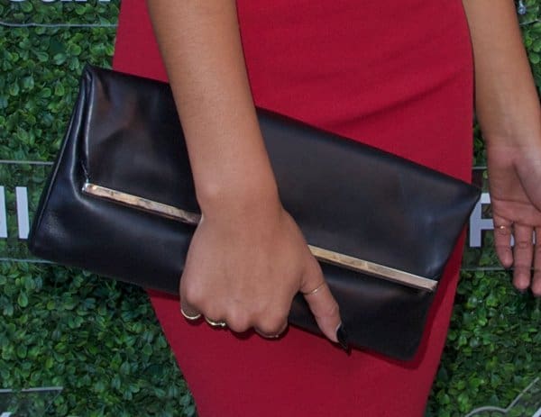 Chanel Iman carried the sleek Michael Kors Collection ‘Taylor’ elongated clutch, a black reptile-embossed accessory that added a bold finish to her rose-colored dress