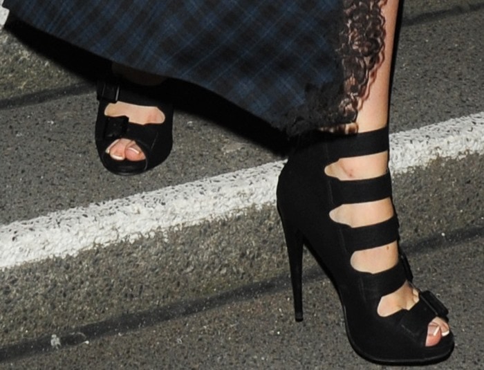 Laura Whitmore highlights her French pedicure in bold black strappy heels with multiple buckles and sky-high stiletto heels