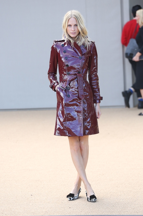 Poppy Delevingne stuns in an oxblood red trench coat and zebra-printed pumps at Burberry Prorsum's SS14 show during London Fashion Week on September 16, 2013