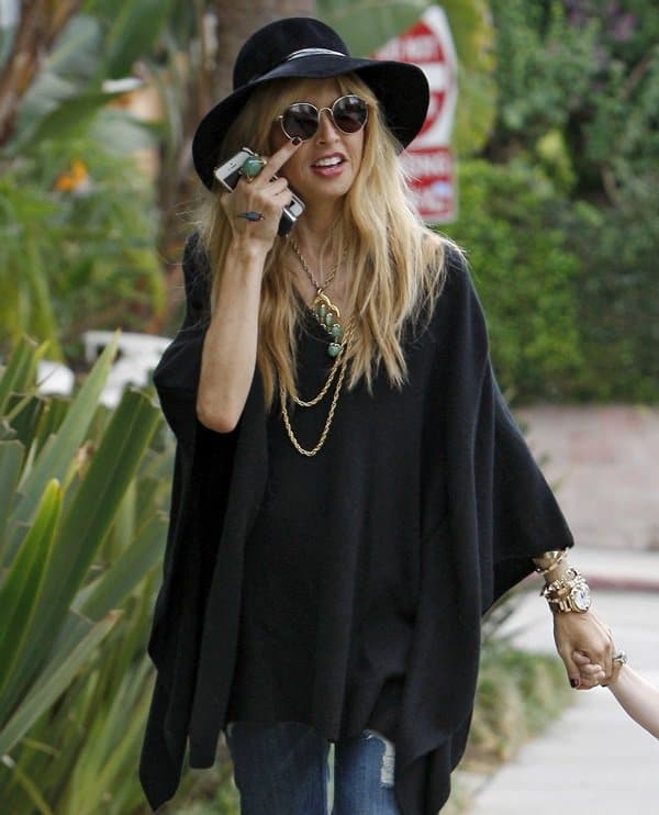 Rachel Zoe black caftan top Rachel Zoe was spotted in a chic bohemian-inspired ensemble featuring a black caftan top and flared jeans