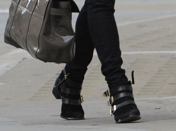A close-up of Fearne Cotton's edgy black ankle boots with multiple gold buckles, adding a bold, stylish touch to her winter outfit