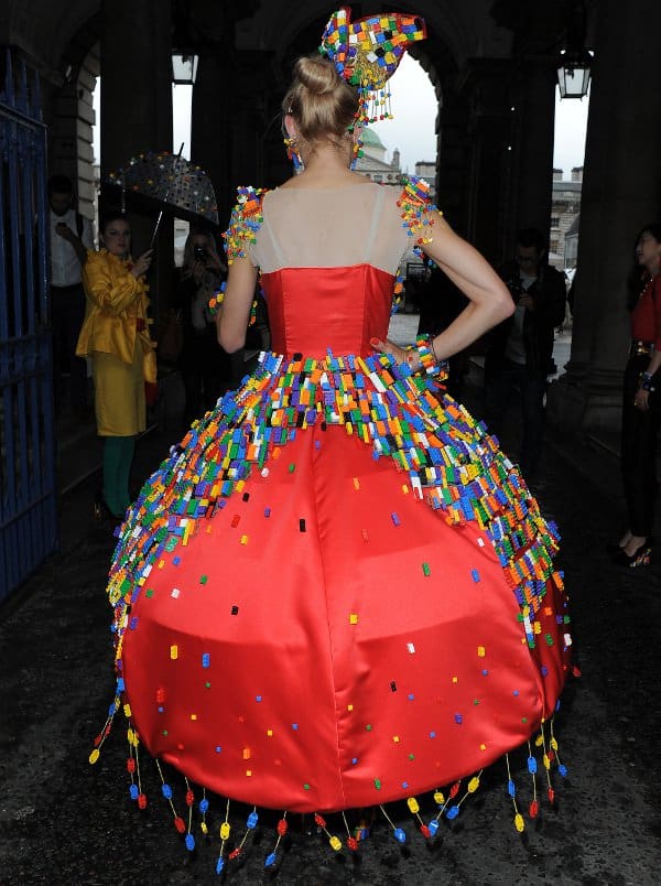 Seen from the back, Anne-Sophie Cochevelou’s dramatic LEGO couture dress revealed cascading brick embellishments, dangling tassel details, and a sculptural satin silhouette that transformed colorful toy pieces into wearable runway art at London Fashion Week