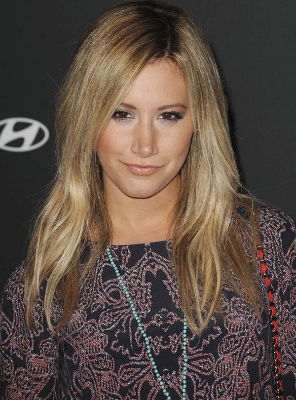 Ashley Tisdale showcasing her light blue rosary necklace at the premiere