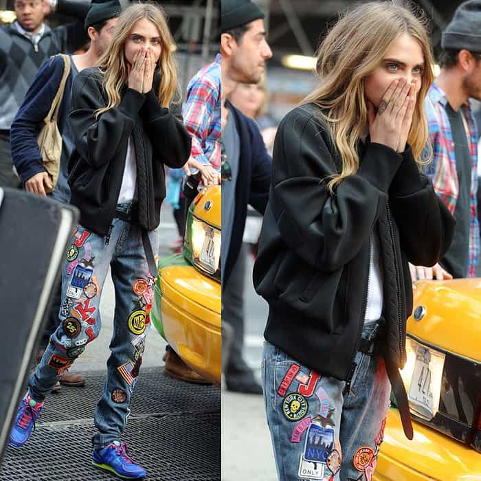 Backstage at a DKNY photoshoot in New York City, Cara Delevingne keeps it effortlessly cool on October 14, 2013, styling patch-covered jeans with sporty blue-and-green sneakers that underscore the label’s streetwear edge