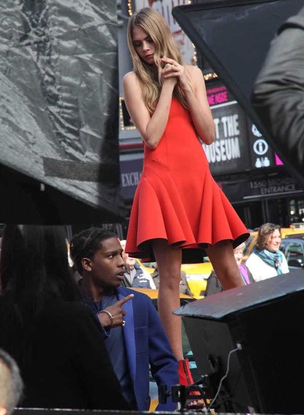 Cara Delevingne captures attention in a vibrant red dress and heels while shooting DKNY’s Spring 2014 campaign