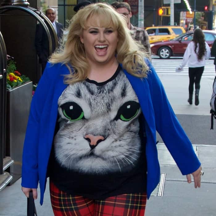 Rebel Wilson smiling while wearing a cat face print shirt and a cobalt blue blazer