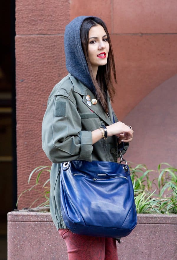 Victoria Justice on the set of 'Naomi and Ely’s No Kiss List,' wearing a Vintage Renewal Surplus F2 olive army jacket, Current/Elliott paprika ankle skinny snake print jeans, and an electric blue crossbody bag