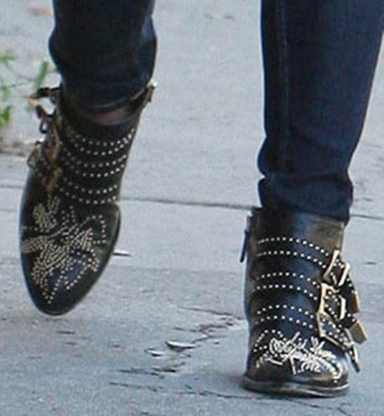 A closer look at Ashley Greene's iconic Chloe Susanna studded buckled boots, showcasing their intricate gold embellishments and rock-inspired buckles