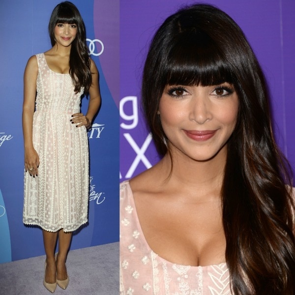 Hannah Simone radiates effortless elegance in a delicate pale pink Oscar de la Renta dress with intricate embroidery, pairing it with classic nude Stuart Weitzman pumps and soft, cascading waves with full bangs for a romantic, feminine finish