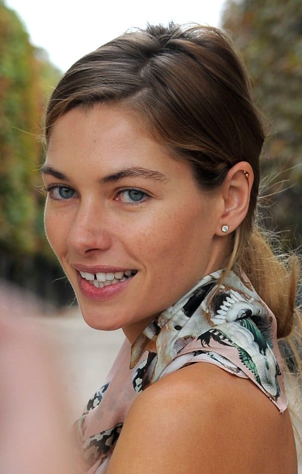 Jessica Hart accessorizes her outfit with an exquisite silk scarf worn around her neck like a tie