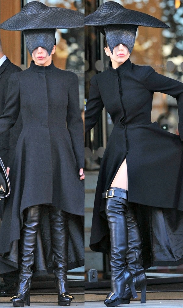Lady Gaga leaving her London hotel on October 30, 2013, in a striking high-low Alexander McQueen coat, over-the-knee leather boots with bold buckles, and a dramatic woven Philip Treacy hat covering half her face