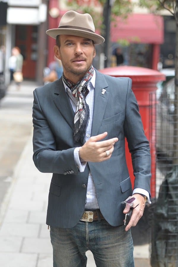 Matt Goss showcases his iconic style with a choker scarf and fedora, adding a touch of sophistication to his casual look