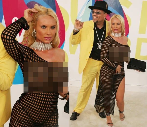 Coco arrives at the 2005 MTV Video Music Awards in a revealing black fishnet gown styled with a dramatic crystal choker, strappy metallic heels, and a thigh-high slit, turning the red carpet into a spectacle of early-2000s celebrity excess alongside husband Ice-T in Miami on August 28, 2005