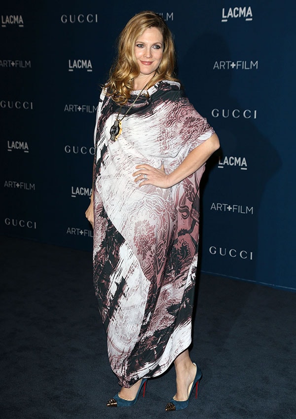 Embracing comfort and confidence, Drew poses gracefully on the blue carpet in her patterned Westwood caftan paired with statement jewelry