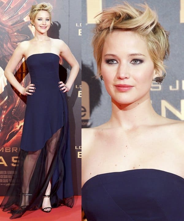 Jennifer Lawrence toughens a flowing navy Christian Dior gown with spiked Anthony Vaccarello sandals, using sharp, sculptural details to balance the softness of her sheer high-low silhouette