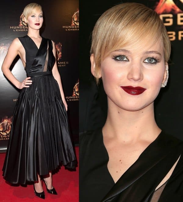 Jennifer Lawrence styled her pleated Christian Dior Fall 2013 dress with Christian Louboutin Air Chance slingback pumps, a sculptural diamond ear cuff, and deep wine lips at the Paris premiere of The Hunger Games: Catching Fire