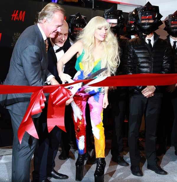 Lady Gaga cuts the ribbon to open the new HM store while wearing a Kerin Rose Gold jumpsuit