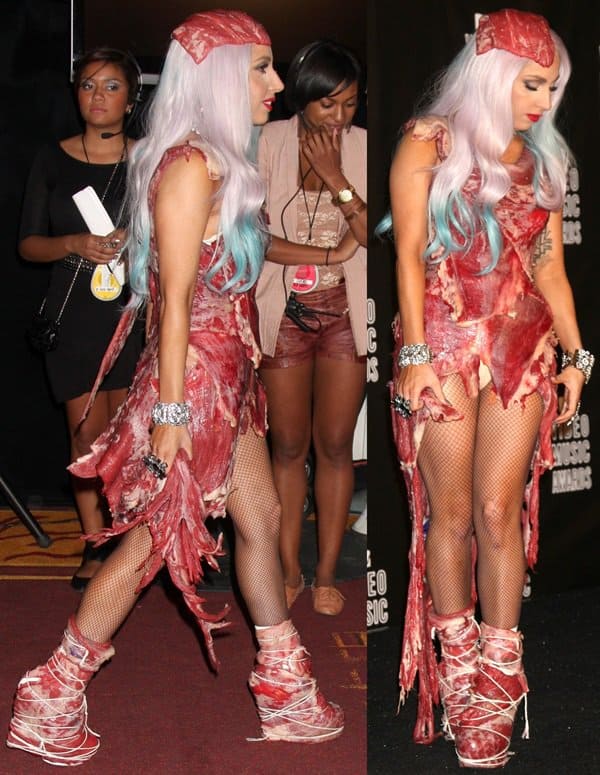 Lady Gaga arrives backstage at the 2010 MTV Video Music Awards wearing her infamous raw meat dress designed by Franc Fernandez, pairing the controversial look with matching meat-covered platform boots wrapped in butcher’s twine, fishnet tights, and platinum hair streaked with blue at the Nokia Theatre in Los Angeles on September 12, 2010