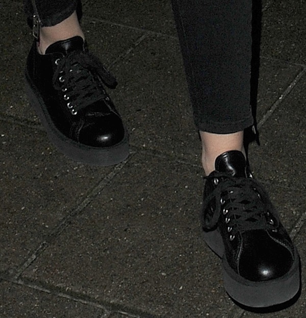 Stepping out with Cara Delevingne, Miley Cyrus completes her look with a pair of black platform lace-up shoes by Comme des Garçons, a cult favorite for their daring, edgy designs
