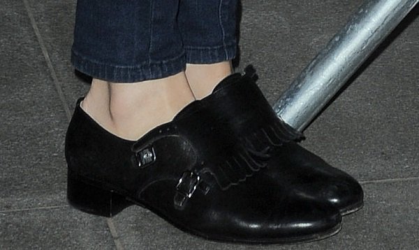 A closer look at Pixie Lott's black low-heeled loafers, featuring stylish fringe and buckle details