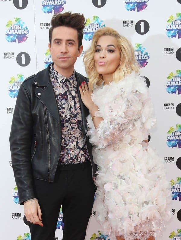 Rita Ora poses with Nick Grimshaw at the 2013 BBC Radio 1 Teen Awards, showing off her whimsical feathered Marchesa dress alongside the host’s edgy leather-and-floral look