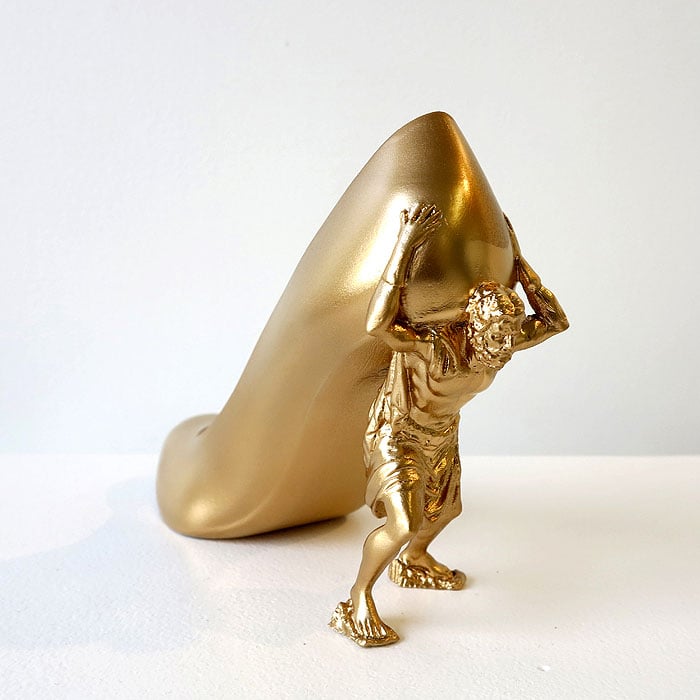 The ‘Gold Digger’ heels, inspired by Alison, feature a gilded figure straining under the weight of the shoe—an arresting metaphor for materialism, desire, and the burdens that come with chasing wealth