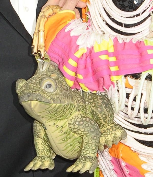 Close-up of Su Pollard's frog-shaped purse, paired with a colorful, neon fringed jacket at the 'Nutcracker on Ice' press night at the London Palladium