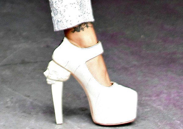 Her ivory platform pumps stood out with towering blocky heels and a gothic twist—skull detailing carved into the back