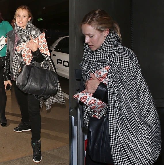 Kristen Bell arrives at LAX in a chic black-and-white houndstooth wrap, black leather-trimmed jacket, black pants, and sneakers, effortlessly maintaining her stylish appearance despite her fatigue