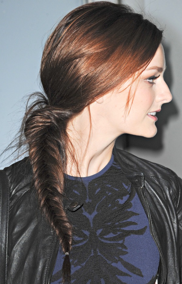 Lydia Hearst wears her long hair swept to one side in a loose fishtail braid, softening the look with an effortless, slightly undone finish that complements her edgy ensemble