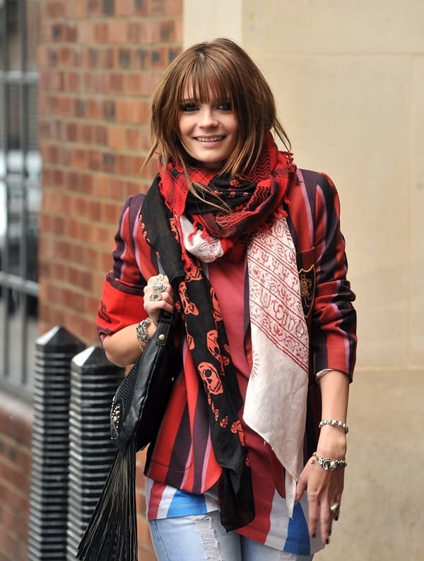 Mischa Barton poses for the photographers in a black Alexander McQueen scarf paired with a colored tee and an even more colorful blazer on April 21, 2009