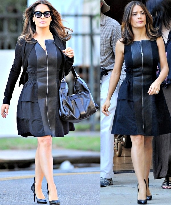 Salma Hayek exudes effortless style on set, pairing a sleek black zip-front dress with classic black pumps and a chic oversized handbag