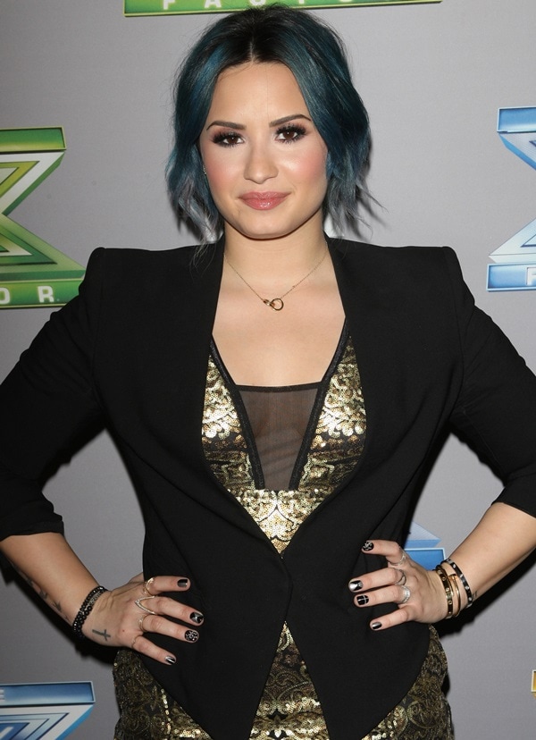 Demi Lovato rocks a bold blue updo paired with soft glam makeup featuring rosy cheeks and a nude lip