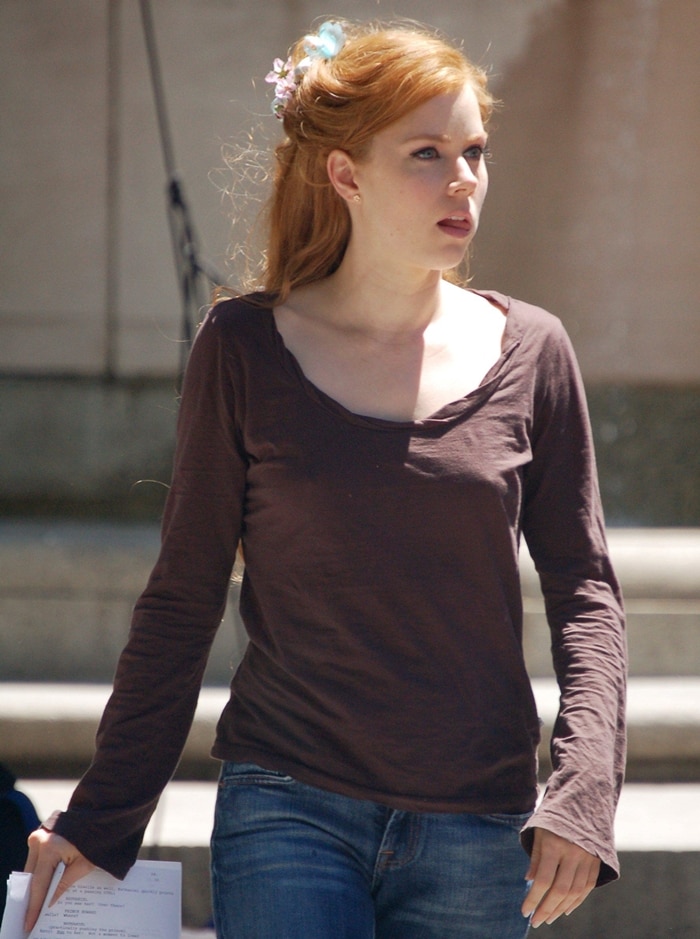 Amy Adams pictured on the set of Enchanted in May 2006, casually dressed and reviewing her script as she prepares to bring the whimsical character of Giselle to life
