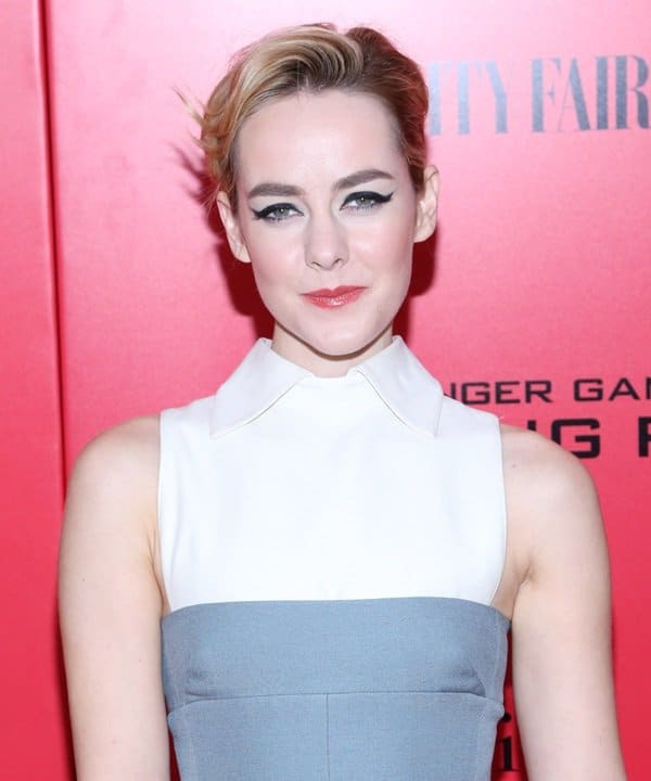 Jena Malone stuns in a sophisticated bicolored Valentino dress, with her bold winged eyeliner and soft pink lips complementing her chic side-swept hairstyle
