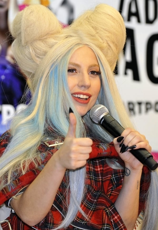 Lady Gaga gives a thumbs-up at the Artpop press conference held at Roppongi Academy Hills in Tokyo, Japan, on December 1, 2013, wearing a bold tartan outfit and her signature avant-garde hairstyle