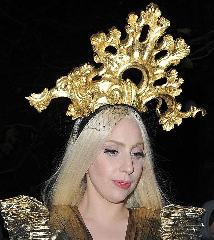 Lady Gaga turns heads with an extravagant golden headpiece and matching outfit