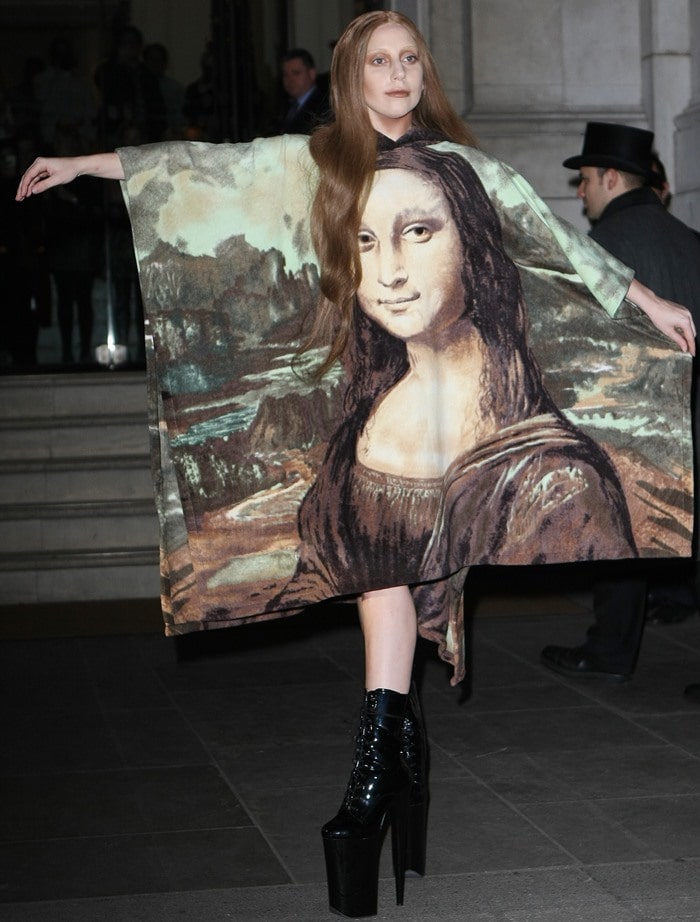Lady Gaga strikes a pose in a dramatic Mona Lisa poncho dress paired with towering black platform boots as she leaves the Langham Hotel in London