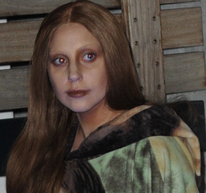 Lady Gaga's eye makeup features a dramatic coppery gold shade extending to the sides of her nose